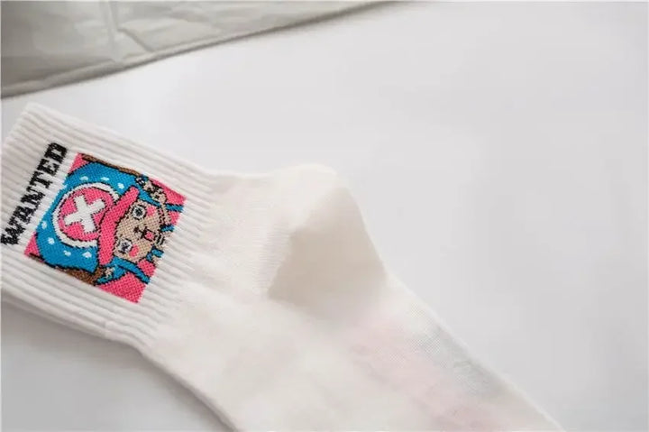 One Piece Chopper socks, white with embroidered design, folded neatly in a box with denim fabric backdrop.