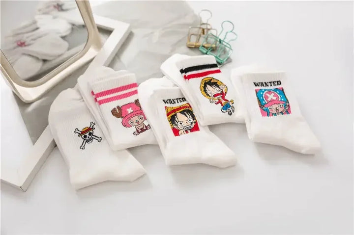 One Piece Luffy and Chopper socks, white with embroidered designs, neatly folded in a box with denim background for display.